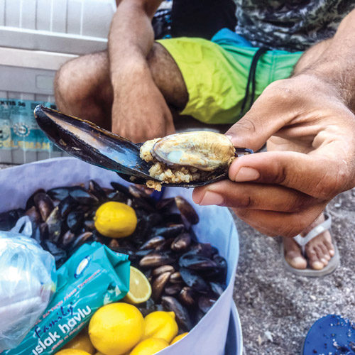 Man selling mussels and rice on the beach.
